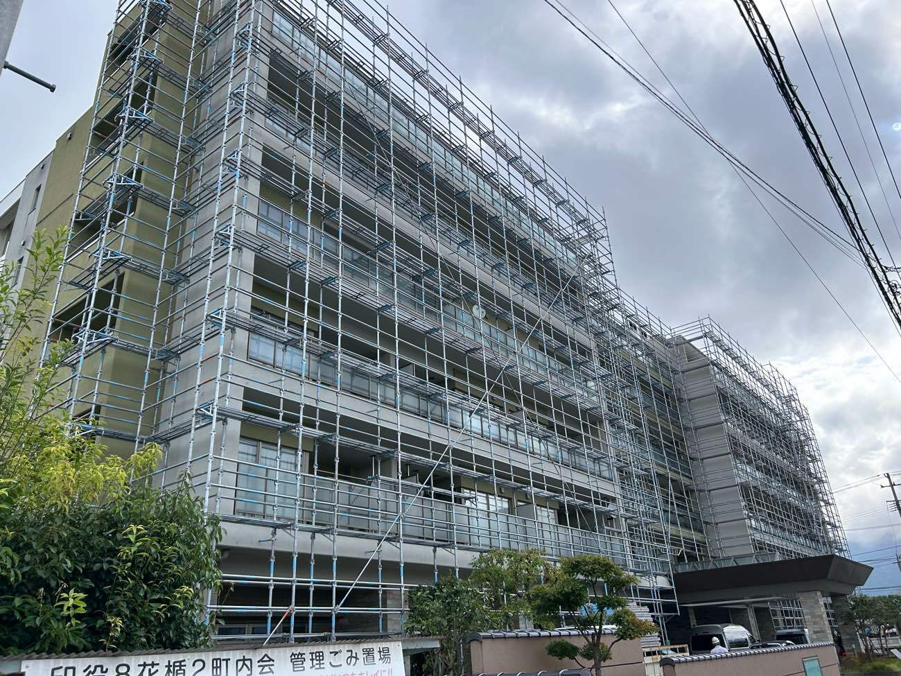 大規模修繕工事のため、建物全体に足場が組まれたマンションの外観。